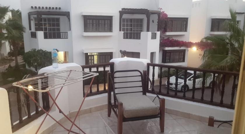 a living room with a balcony and a table with chairs, Private Apartment in Sharm El Sheikh
