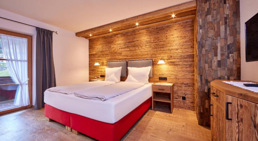 a bedroom with a large bed and a large window, Landhaus Sonnenbichl Mittenwald in Mittenwald