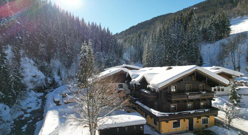 a snow covered ski slope with a cabin, Pension Lederergutl in Saalbach