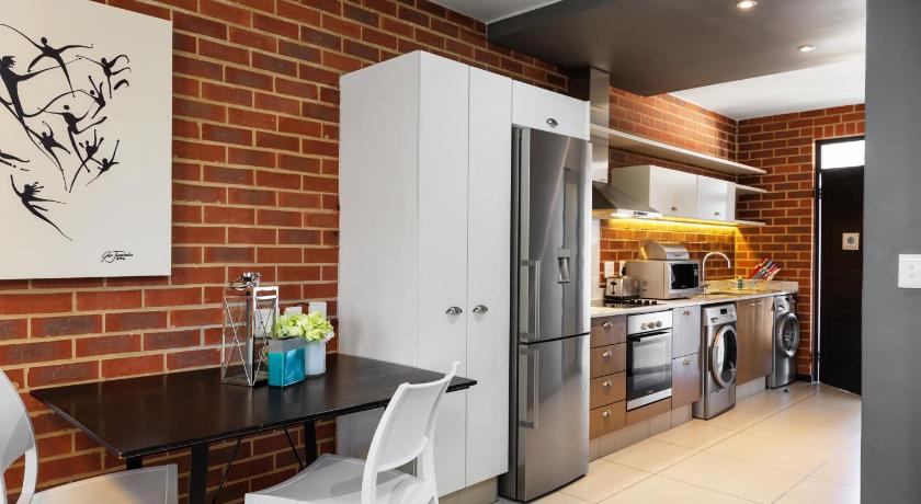 a kitchen with a refrigerator and a table, C.A.G The Vantage in Johannesburg