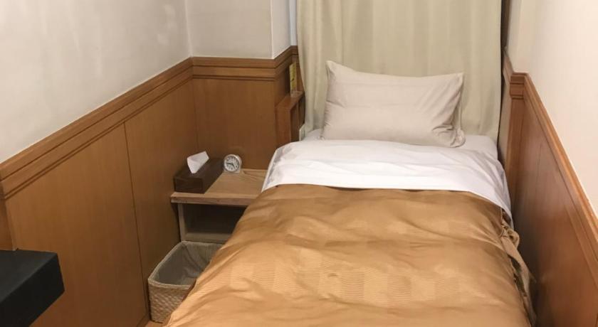 a bedroom with a bed and a desk, Business Hotel Crescent in Tokyo