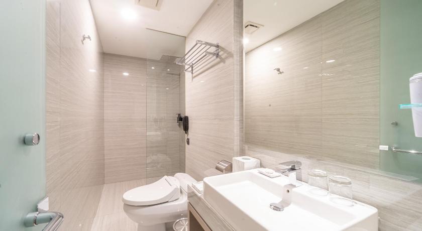 a bathroom with a toilet, sink, and bathtub, Hotel Platinum Tunjungan Surabaya in Surabaya