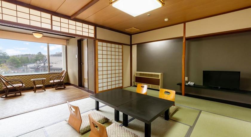 a living room filled with furniture and a tv, Kusatsu Onsen Daitokan in Kusatsu