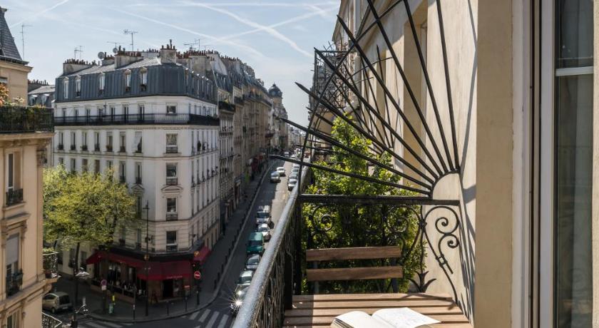 a patio area with a balcony and an umbrella, Boronali Hotel in Paris