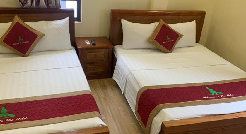 two beds in a room with two lamps, Traveler's Comfort Hotel in Hạ Long