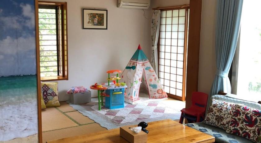 a person sitting at a table in a living room, Beach House  YOMITAN  ビーチハウス読谷 in Okinawa Main island