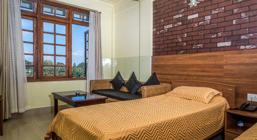 a hotel room with a bed and a desk, APSARA GUEST HOUSE in Shillong
