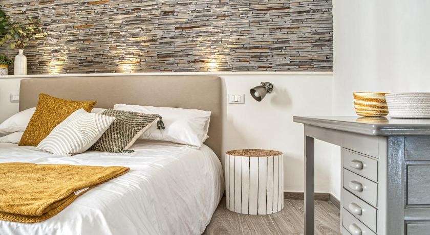 a bedroom with a white bedspread and white pillows, Casa Checca appartamenti per vacanze in Caprarola