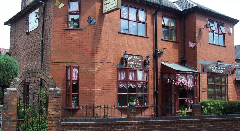 a brick building with a clock on the front of it, Butterfly Guest House in Manchester