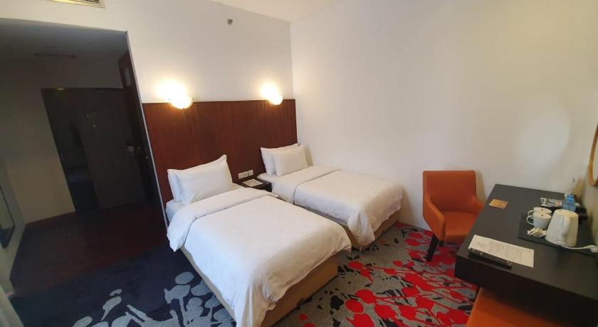 a hotel room with two beds and a desk, Liberty Hotel Jakarta Thamrin in Jakarta