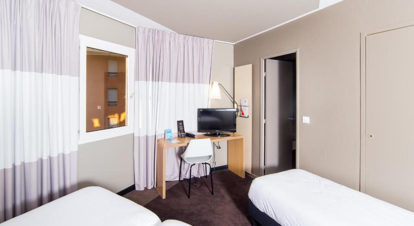 a hotel room with a bed and a television, Ibis Toulouse Purpan in Toulouse