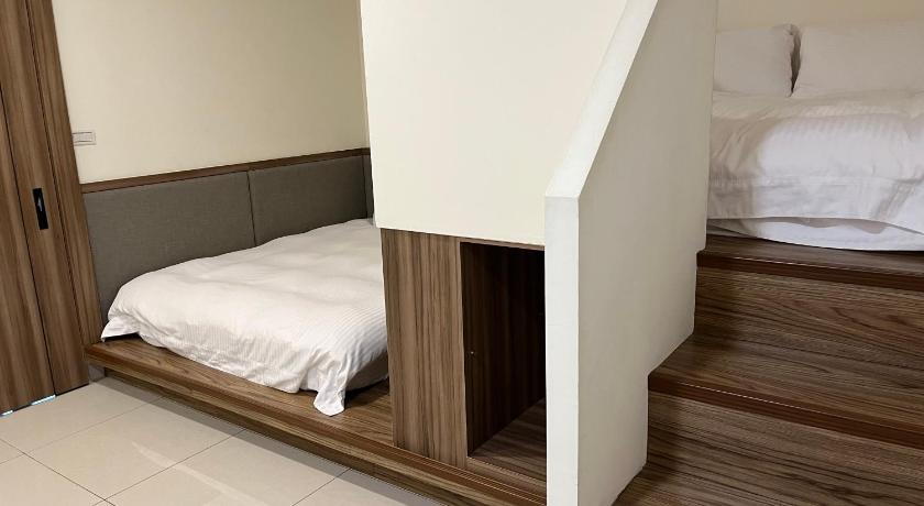 a bedroom with a white bed and wooden flooring, Lan Feng Su B&B in Yilan
