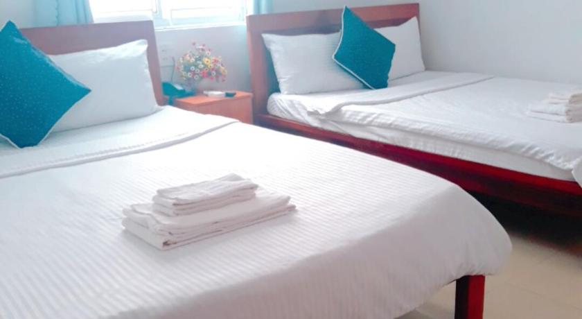 a hotel room with two beds and two lamps, Hoang Anh Hotel in Quy Nhon (Binh Dinh)