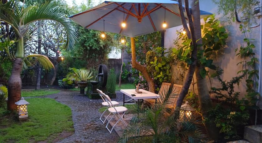 a patio area with a table, chairs, and umbrella, Dalum Homestay in Bali