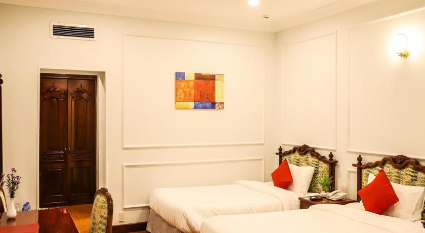 a hotel room with two beds and a large window, Riverside Hotel Saigon in Ho Chi Minh City