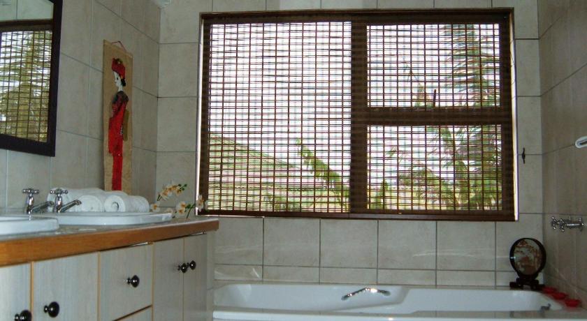 a bathroom with a tub, sink and window, Smart Villa Guest House in East London