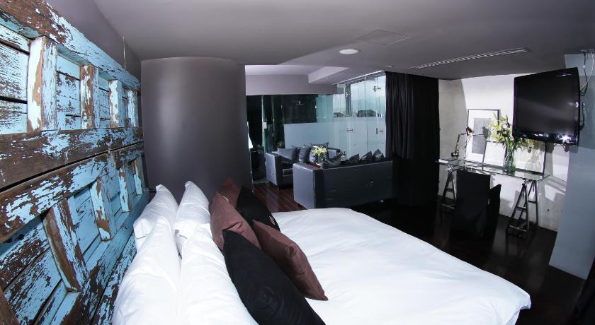 a person laying on a bed in a room, Demetria Hotel in Guadalajara