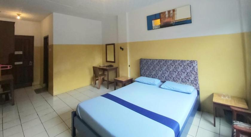 a bedroom with a bed and a desk, Sentosa Hotel & Restaurant - tersertifikasi CHSE dari Kementerian Pariwisata dan Ekonomi Kreatif in Bekasi