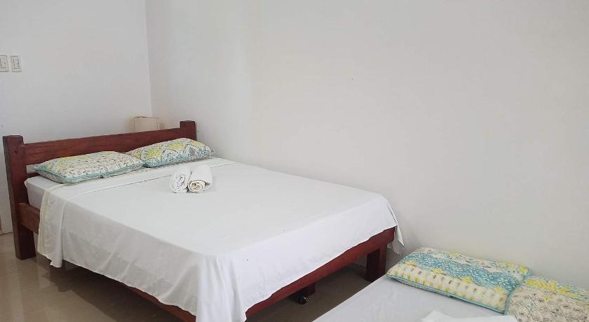 a bedroom with a bed and a dresser, Catalina`s Inn in Bohol