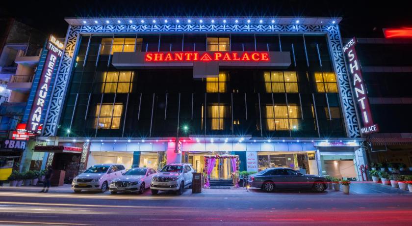 a large building with a neon sign on the side of it, Hotel Shanti Palace in New Delhi and NCR