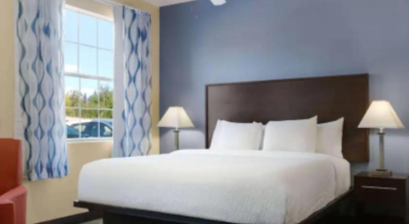 a hotel room with a bed and two lamps, Days Inn & Suites by Wyndham Ft. Worth DFW Airport South in Dallas (TX)