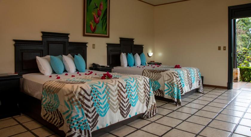 a hotel room with a bed and a table, Arenal Manoa Resort & Hot Springs in La Fortuna