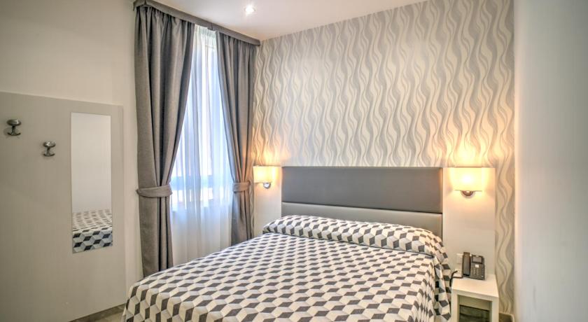 a hotel room with a bed and two lamps, Hotel Porto Di Roma in Civitavecchia