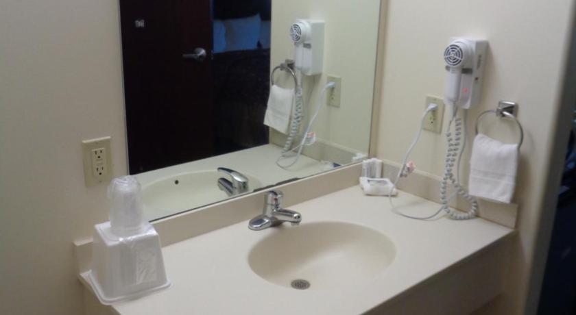 a bathroom with a sink, mirror, and soap dispenser, Fairgrounds Inn in Du Quoin (IL)