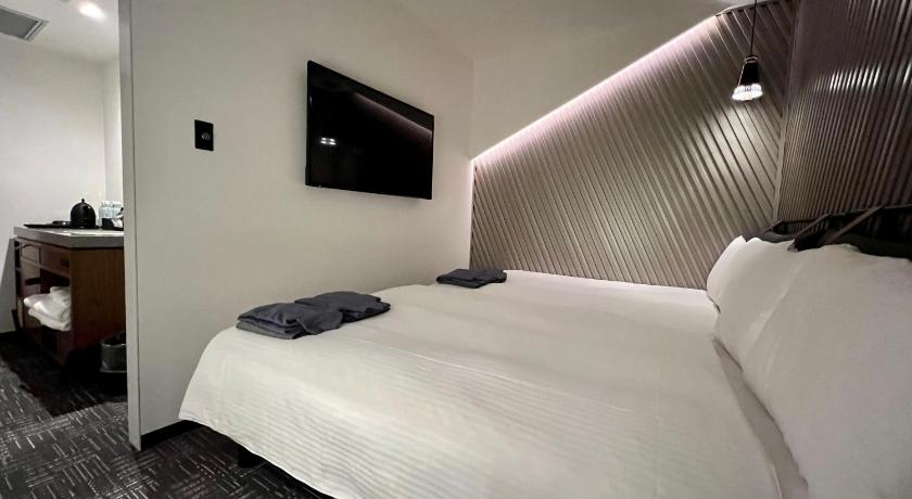 a hotel room with a bed and a television, THE LIVELY FUKUOKA HAKATA in Fukuoka