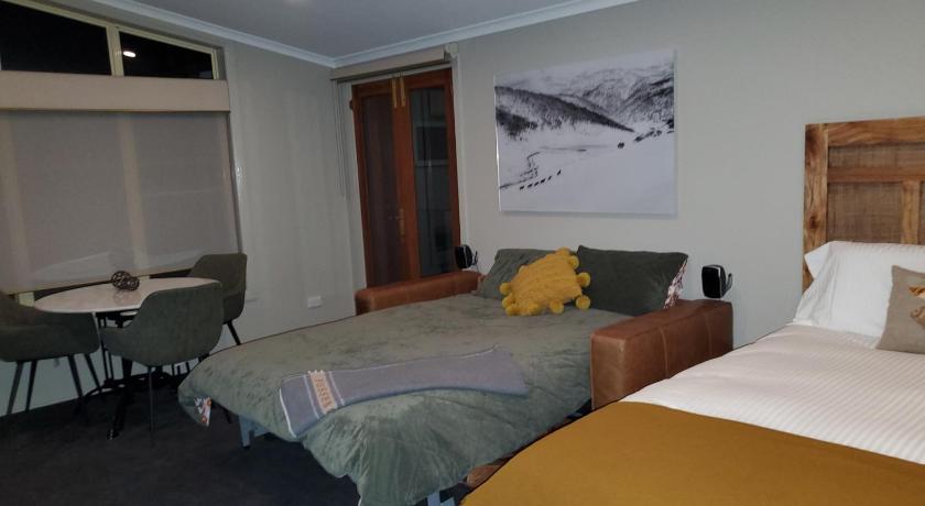 a bedroom with a bed and a desk, Lakeside Studio in Jindabyne