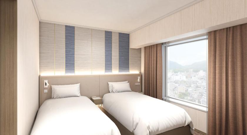 a hotel room with two beds and a window, Miyako Hotel Yokkaichi in Yokkaichi
