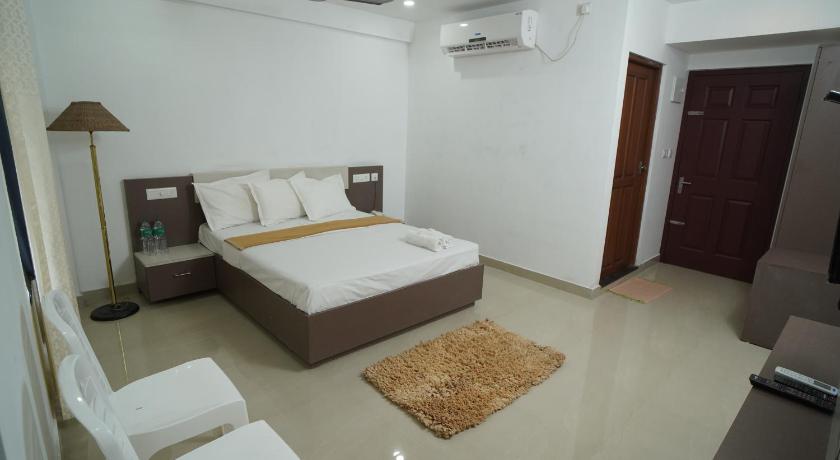 a hotel room with a white bed and white walls, SN ROOMS in Kochi