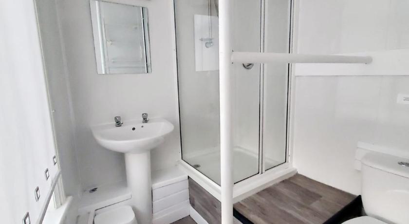 a white toilet sitting next to a bath tub, The Brooklyn Hotel in Blackpool