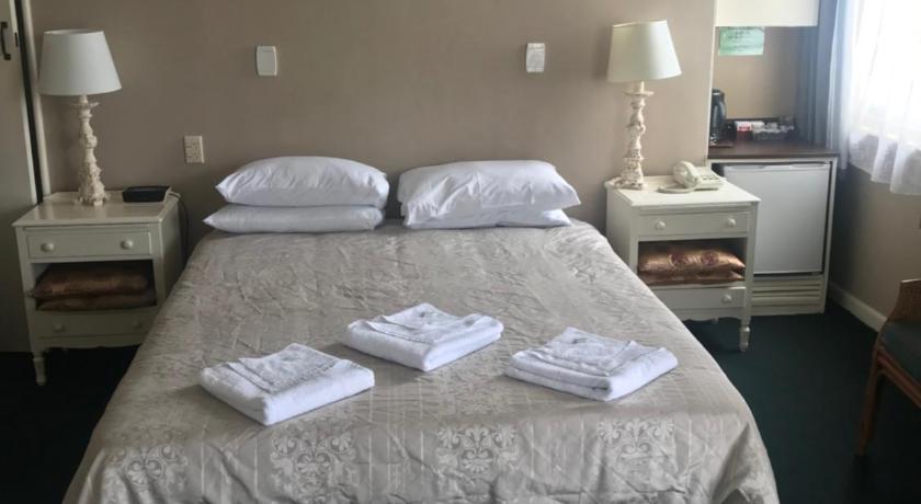 a hotel room with a bed and a desk, Grand Hotel - Whangarei in Whangarei