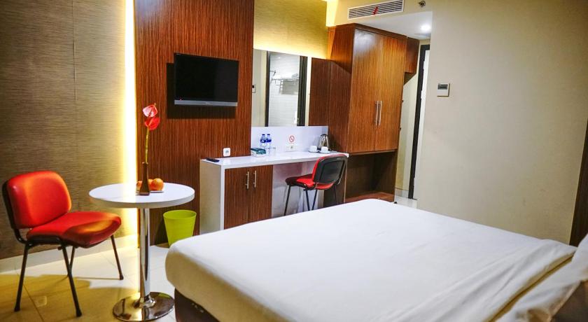 a hotel room with a bed, chair and a tv, Empress Hotel Makassar City Center by LIFE in Makassar