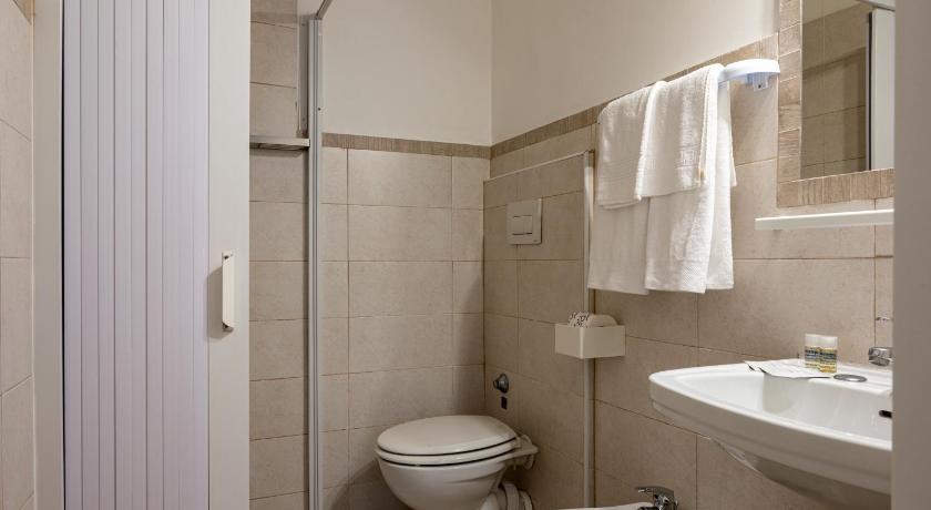 a white toilet sitting next to a white sink, Amadei Hotel Blumen in Pesaro