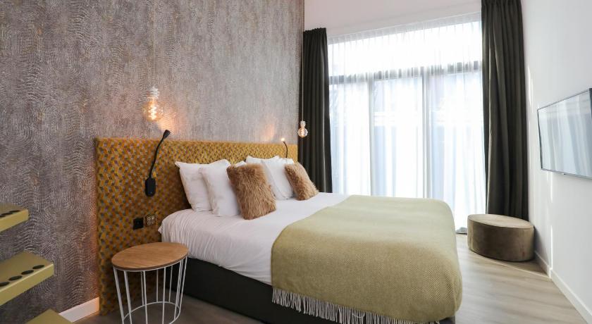a bedroom with a large bed and a large window, Valerius Boutique Hotel in Wormer