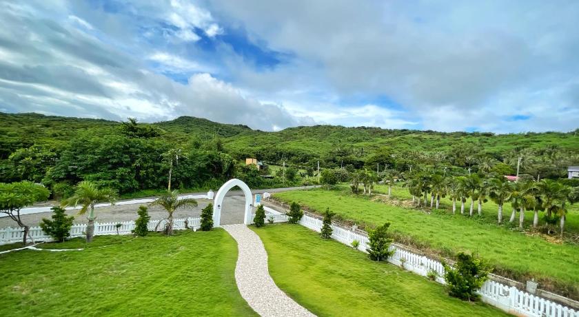 a large white house on a lush green hillside, Wonderful Kenting Hostel in Kenting