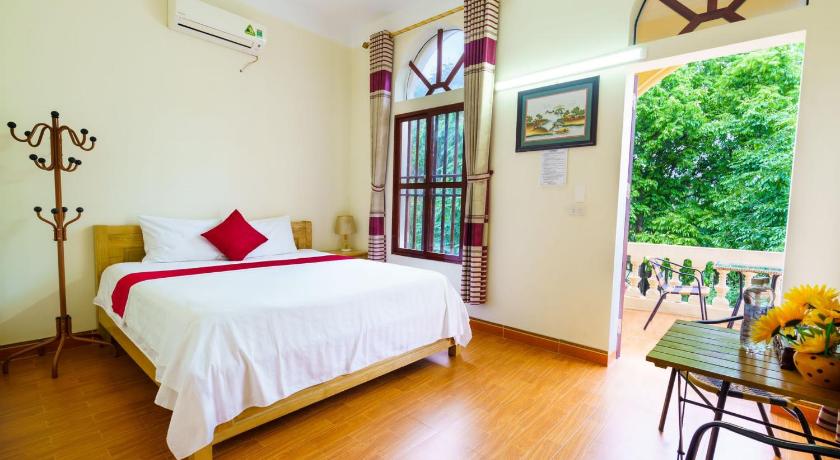 a bedroom with a bed, chair, table and window, Tam Coc Mountain Lake Homestay in Ninh Bình