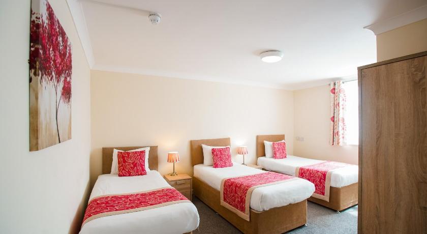 a bedroom with two beds and two nightstands, Craig-y-Don in Blackpool
