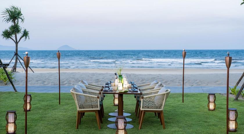 a picnic table set up on a grassy beach, Hoiana Hotel and Suites in Hoi An
