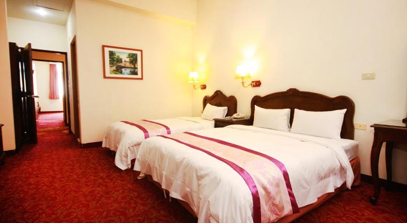 a hotel room with two beds and two lamps, East Commercial Affairs Hotel in Yilan