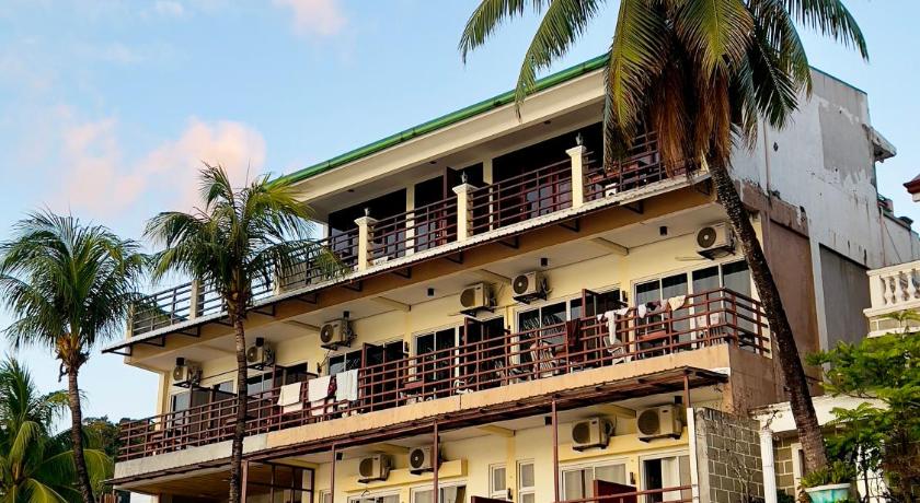 a large building with a large clock on top of it, Rosanna's Pension in Palawan