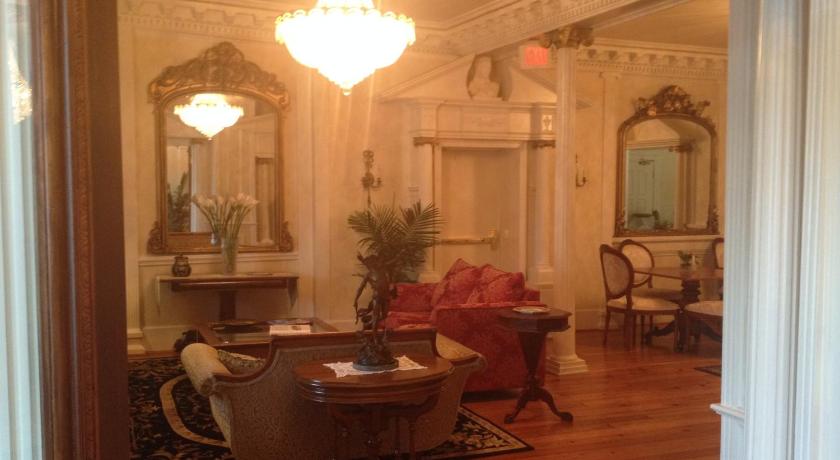 a living room filled with furniture and a large mirror, The Hotel Magnolia in Foley (AL)