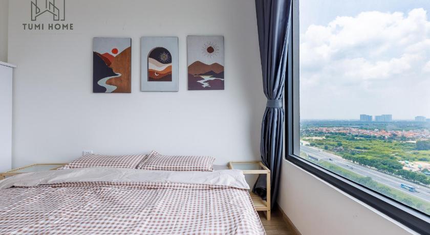 a bedroom with a bed and a painting on the wall, TumiHome - Chuoi can ho cao cap Vinhomes Ocean Park in Gia Lam