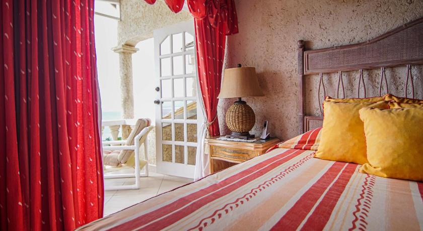 a room with a bed, a table and a lamp, Seacruise Villa in Checker Hall