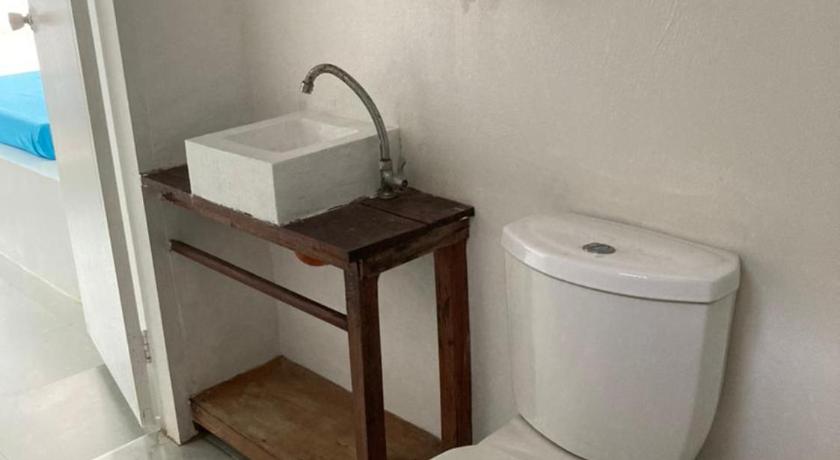 a white toilet sitting in a bathroom next to a wall, Tribal Xperience Port Barton Town in Palawan