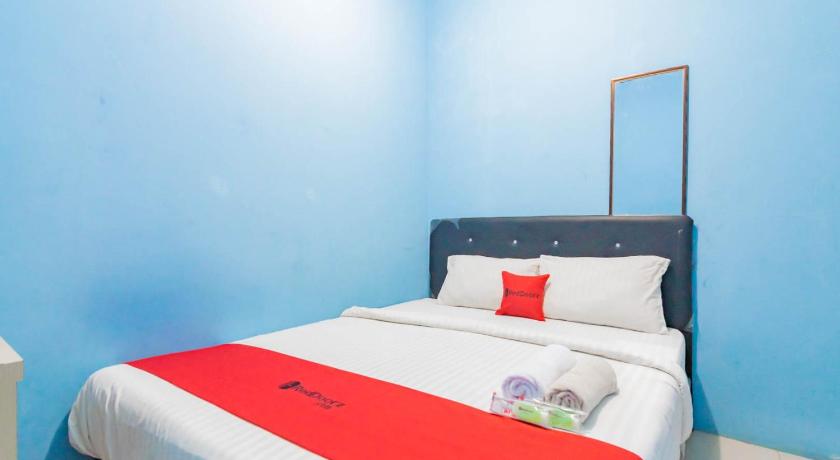 a bedroom with a blue and white striped bedspread, OYO 2302 Blue House Costel in Puncak