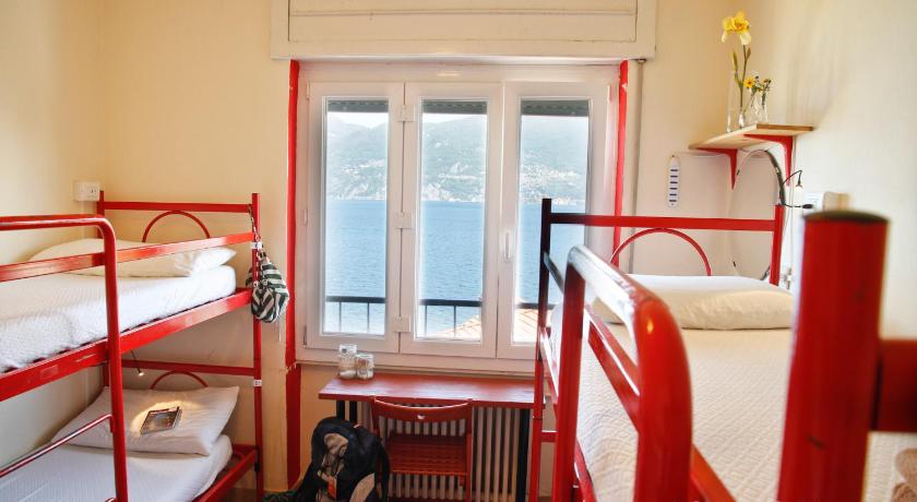 a room with two bunk beds and a toilet, Lake Como Hostel in Menaggio