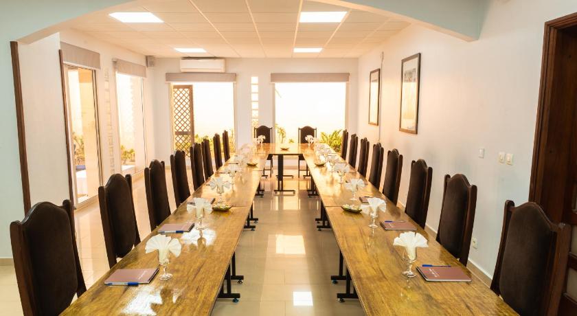 a room filled with tables and chairs with a large mirror, Le Lodge des Almadies in Dakar